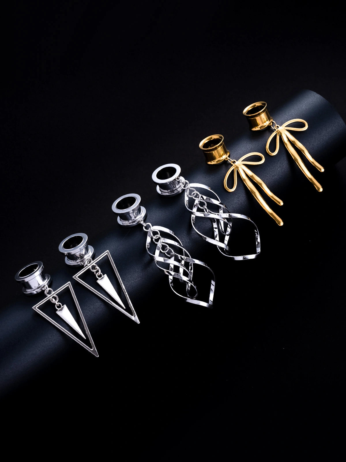 Three sets of product photography for ear-weights. Each set features a detailed close-up of a different heavy, decorative earring designed for stretched earlobes.