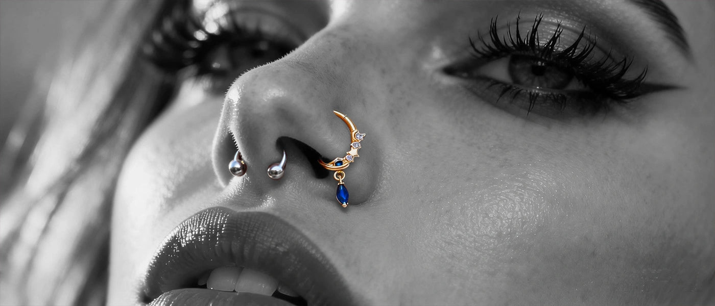 A styled close-up portrait of a model showcasing decorative nose rings.